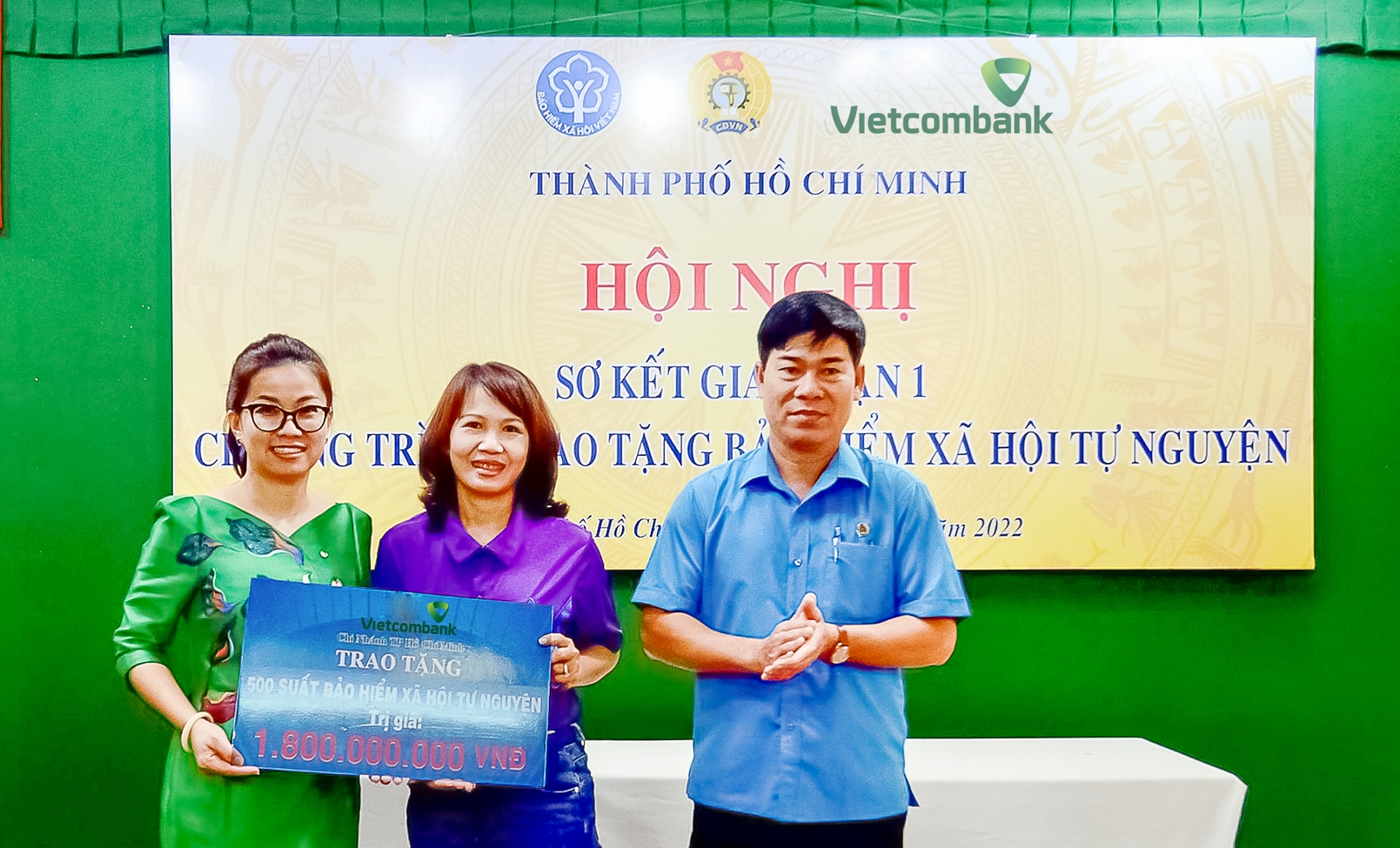 Bà Lê Thị Hòa Bình - Phó Giám đốc Vietcombank TP.HCM (bên trái) trao bảng tượng trưng tái tục BHXH trị giá 1,8 tỷ đồng cho đại diện đoàn viên các nghiệp đoàn nhận BHXH năm 2021