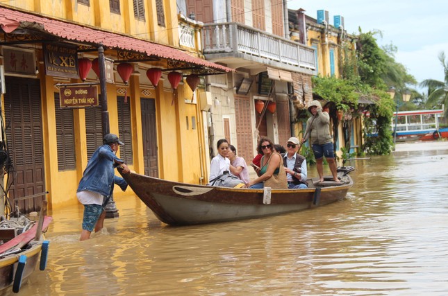 Hội An ngập sâu, du khách thuê thuyền ngắm phố cổ sau bão Noru - Ảnh 1.