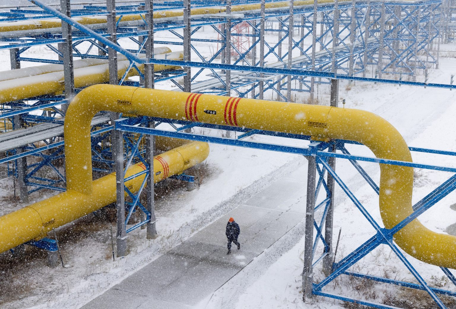 Một công nhân đi bộ dưới hệ thống đường ống trong sân tại một mỏ dầu khí Gazprom ở Sakha- phía đông của Nga. Ảnh: @Getty Images.