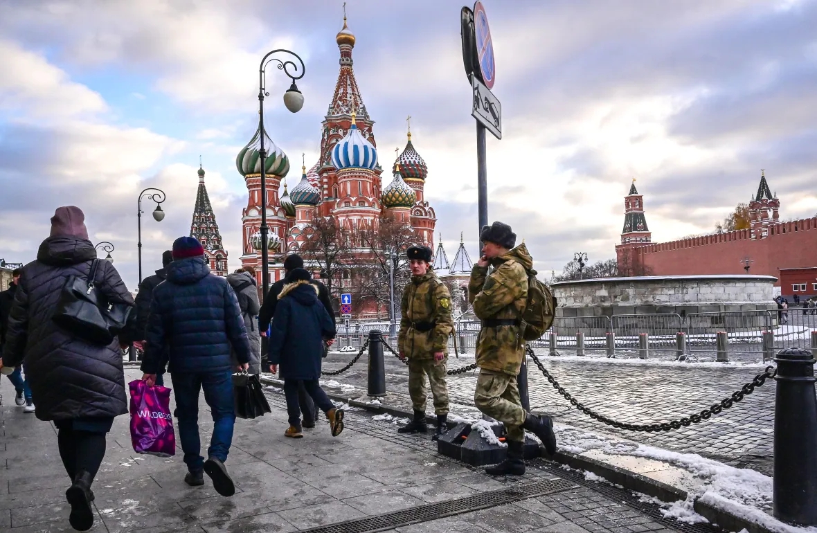 Người đi bộ đi ngang qua hai người lính khi họ đứng ở Quảng trường Đỏ gần Nhà thờ Saint Basil ở Moscow vào tháng trước. Ảnh: @Yuri Kadobnov/AFP.