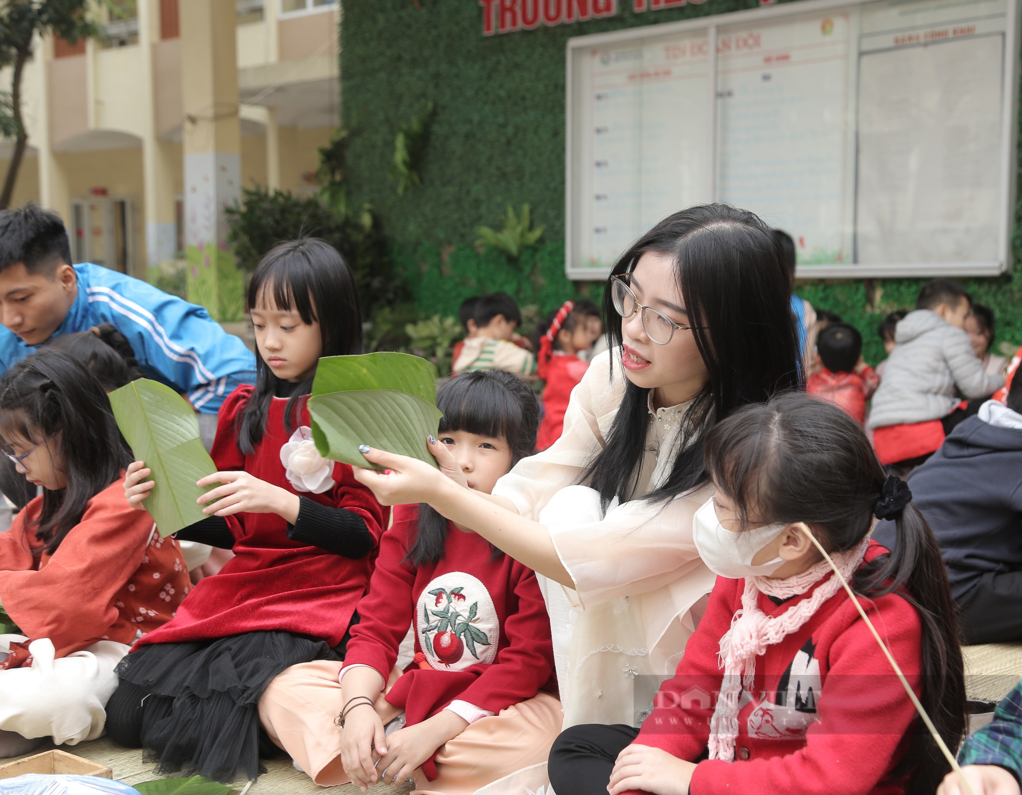 Gần 2.000 học sinh tiểu học ở Hà Nội trải nghiệm gói bánh chưng trên sân trường - Ảnh 3.
