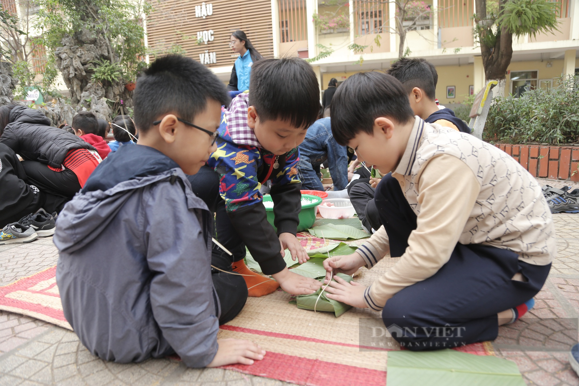 Gần 2.000 học sinh tiểu học ở Hà Nội trải nghiệm gói bánh chưng trên sân trường - Ảnh 4.