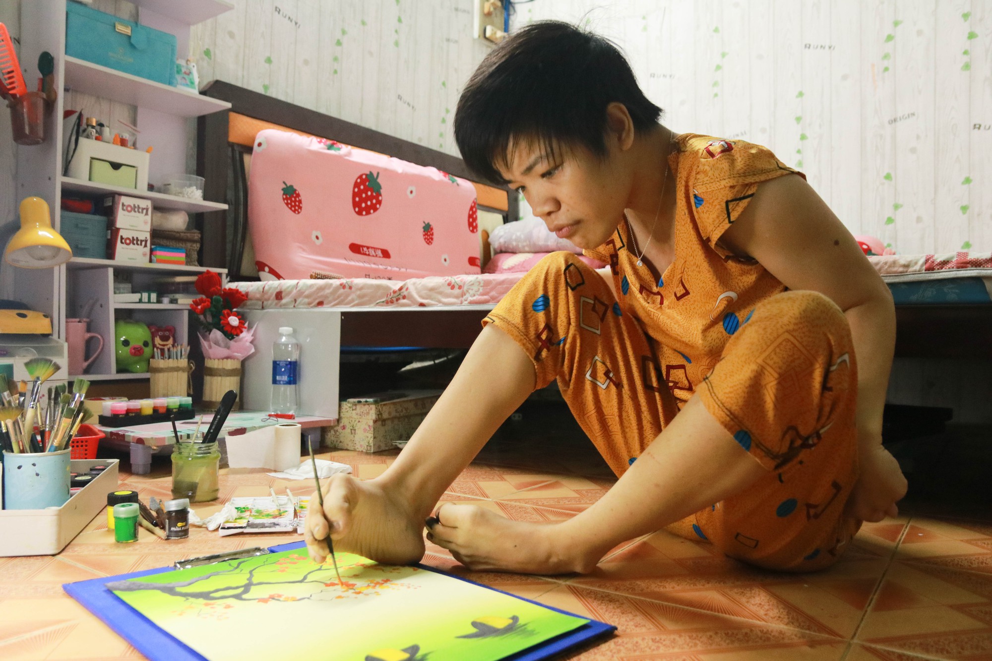 Cô gái khuyết tật ở TP.HCM với niềm đam mê vẽ tranh bằng chân suốt 20 năm - Ảnh 1.