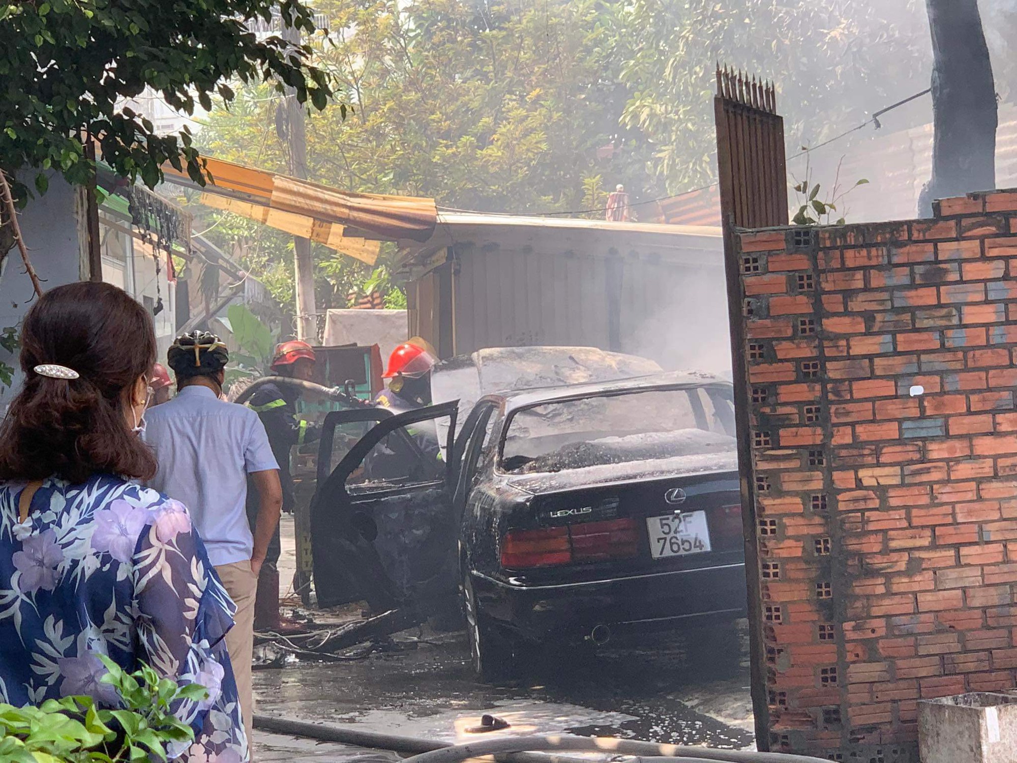 Ô tô Lexus bốc cháy dữ dội khi đang đậu trong khuôn viên nhà dân ở TP.HCM - Ảnh 1.