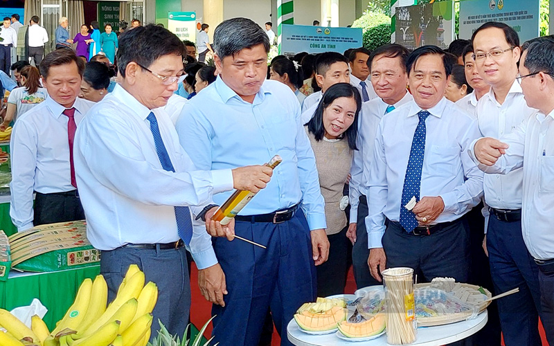 Thứ trưởng Bộ NNPNTT Trần Thanh Nam (giữa) tham quan các sản phẩm nông nghiệp công nghệ cao được triển lãm tại Hội nghị sơ kết 3 năm thực hiện Chương trình mục tiêu quốc gia xây dựng nông thôn mới tỉnh Bình Dương. Ảnh: Trần Khánh