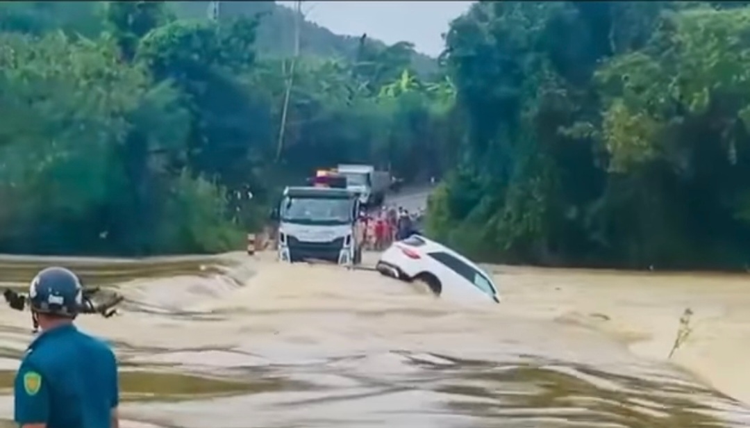 Ô tô Mercedes bị lũ cuốn trôi, hai người trên xe may mắn thoát thân. - Ảnh 1.