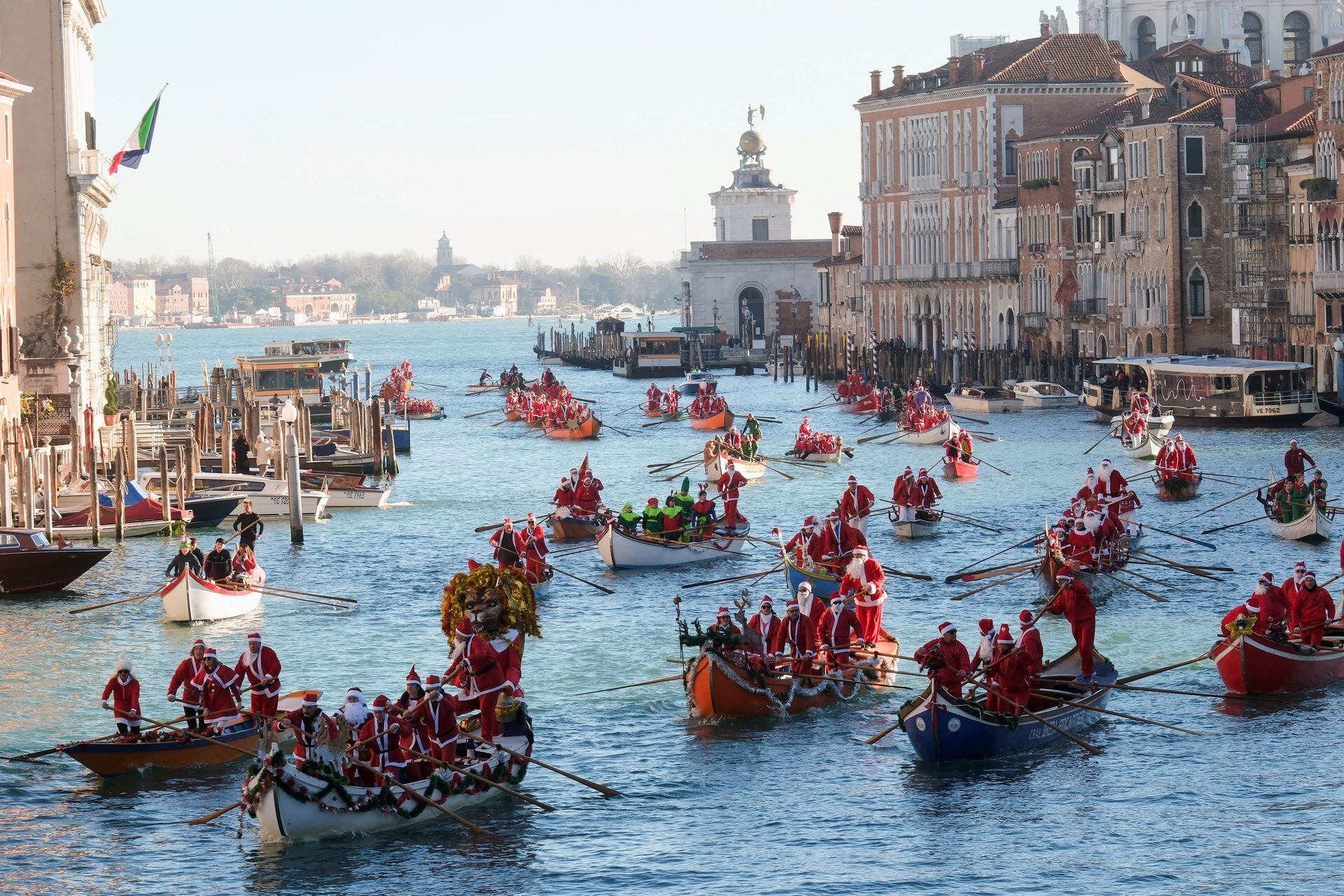 Độc lạ cảnh ông già Noel bỏ xe trượt tuyết, dùng thuyền để đua ở thành Venice- Ảnh 1.