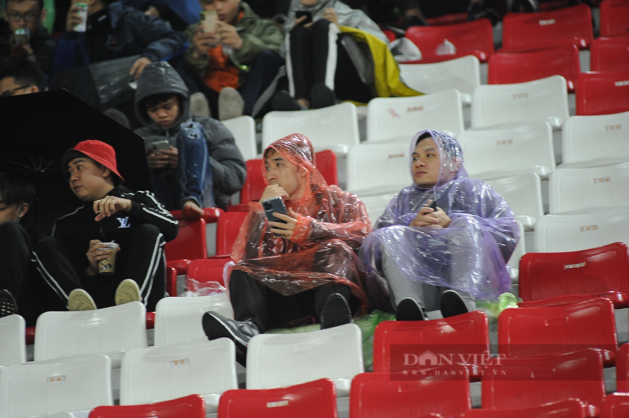 CĐV Hải Phòng dầm mưa cổ vũ đội nhà ở trận đấu mở màn cho V-League 2023 - Ảnh 1.