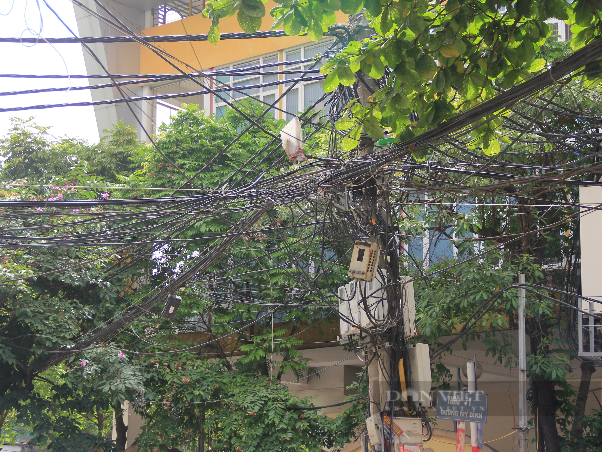 Nhiều tuyến phố ở Hà Nội: Dây điện, cáp viễn thông chằng chịt, “giăng bẫy” người dân - Ảnh 1.