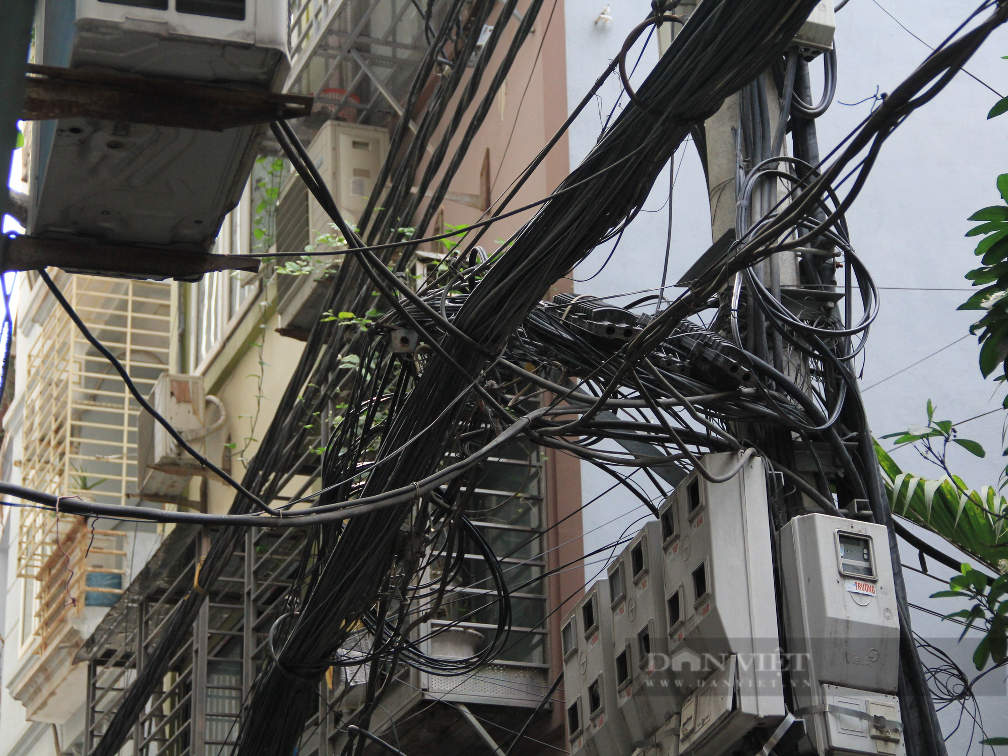 Nhiều tuyến phố ở Hà Nội: Dây điện, cáp viễn thông chằng chịt, “giăng bẫy” người dân - Ảnh 3.