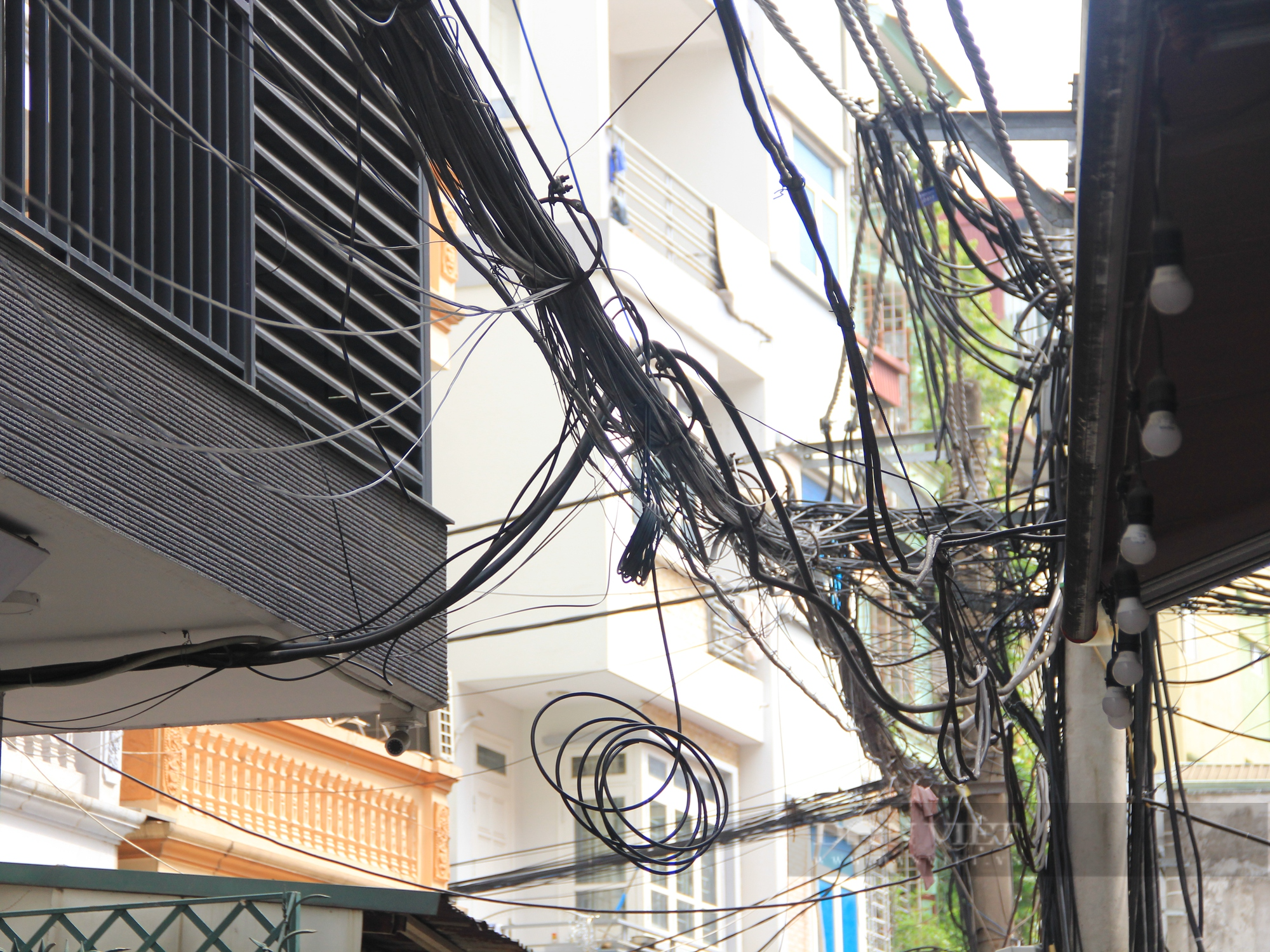 Nhiều tuyến phố ở Hà Nội: Dây điện, cáp viễn thông chằng chịt, “giăng bẫy” người dân - Ảnh 4.
