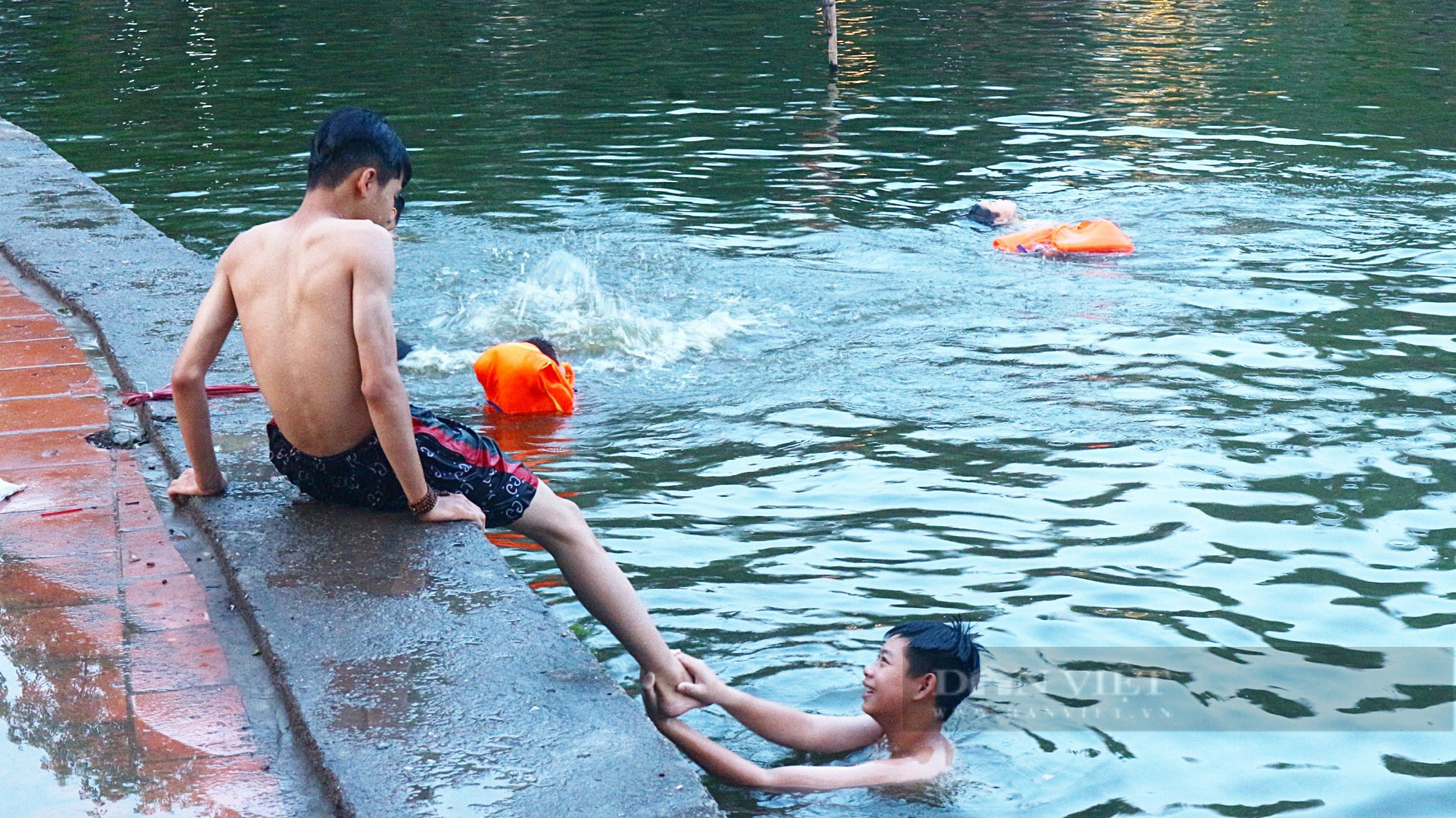 Trẻ em Hà Nội tắm ‘giải nhiệt’ dưới hồ nghìn năm tuổi giữa những ngày nắng nóng - Ảnh 2.