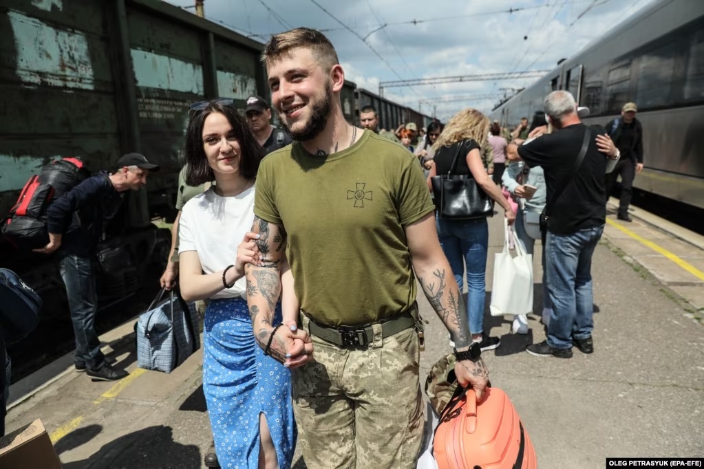 Nghẹn ngào nụ hôn, cái ôm siết của các quân nhân Ukraine ngày đoàn tụ và chia xa ở nhà ga Kramatorsk - Ảnh 4.