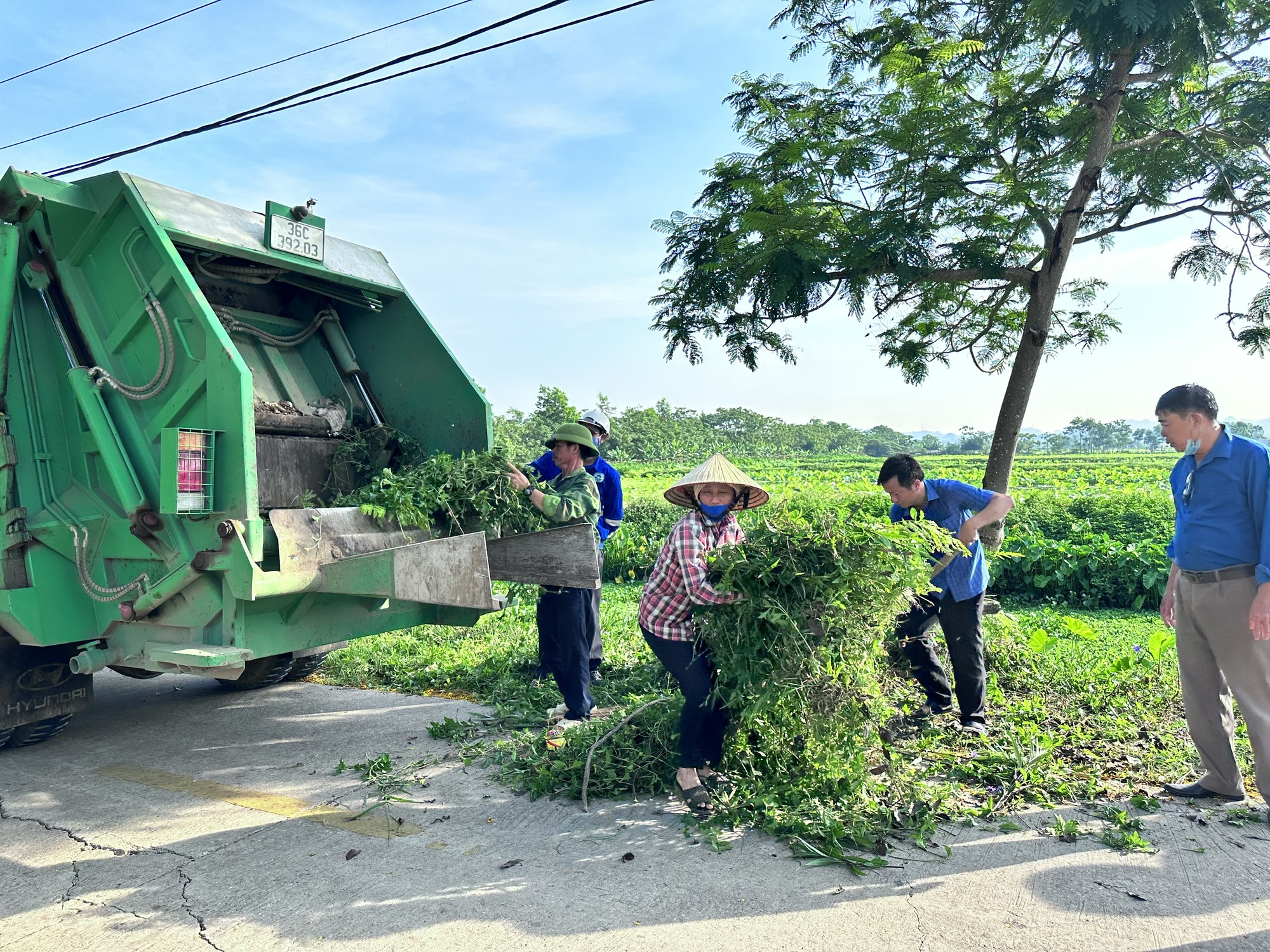 Hàng trăm người dân một xã ở Thanh Hóa rủ nhau phát cỏ, quét dọn đường sá sạch tinh tươm  - Ảnh 1.