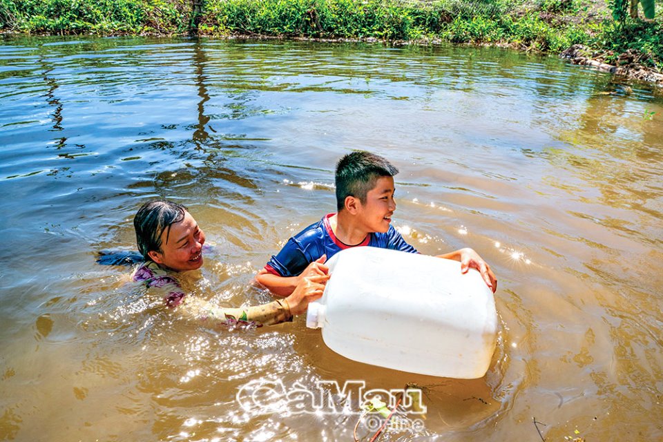 Các chị nông dân ở Cà Mau tung vô số quả dừa khô xuống kênh dạy trẻ em tập bơi, nhiều người đến xem - Ảnh 3.