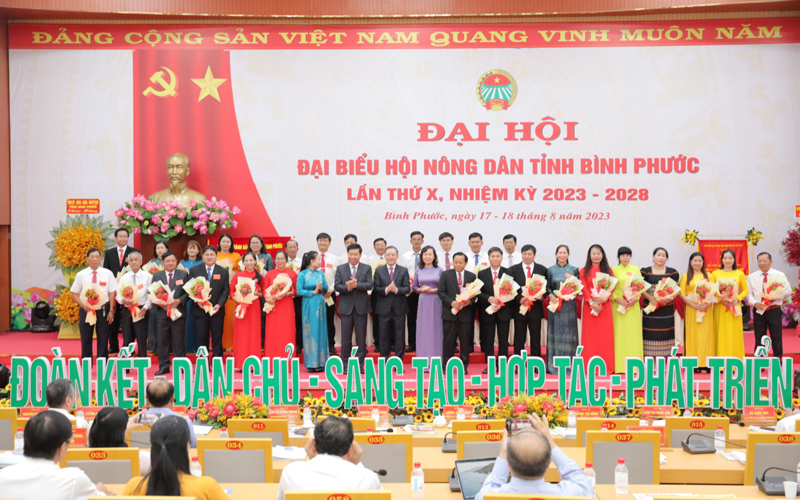 Lãnh đạo Trung ương Hội Nông dân Việt Nam và lãnh đạo tỉnh Bình Phước tặng hoa chúc mừng các ủy viên Ban Chấp hành, Ủy ban Kiểm tra; đại biểu chính thức và đại biểu dự khuyết tham dự đoàn đại biểu dự Đại hội toàn quốc Hội Nông dân Việt Nam lần thứ VIII. Ảnh: T.L