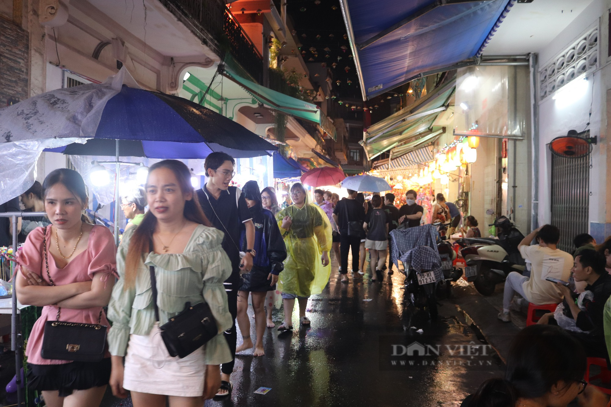 Bất chấp mưa lớn, người Sài Gòn vẫn che dù, mặc áo mưa đi chơi Trung thu - Ảnh 1.