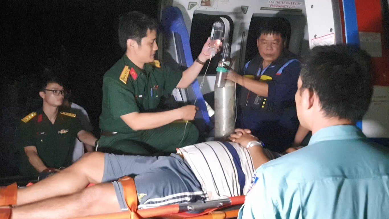 Trực thăng đưa 3 ngư dân bị nạn từ đảo Sinh Tồn vào bờ điều trị - Ảnh 2.