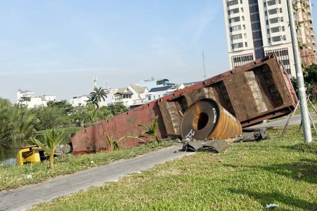 Xe đầu kéo chở cuộn thép 20 tấn va vào dải phân cách, lao xuống hồ nước ven đường- Ảnh 1.