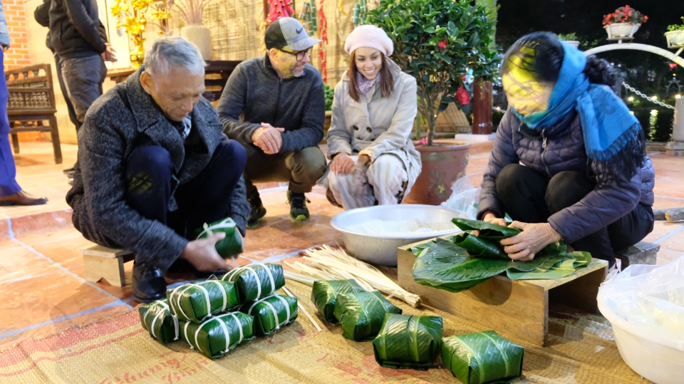 Khách Tây thích thú uống trà, gói bánh chưng trong không gian Tết Xưa ở Lễ hội hoa đào, quất cảnh Hà Nội - Ảnh 2.