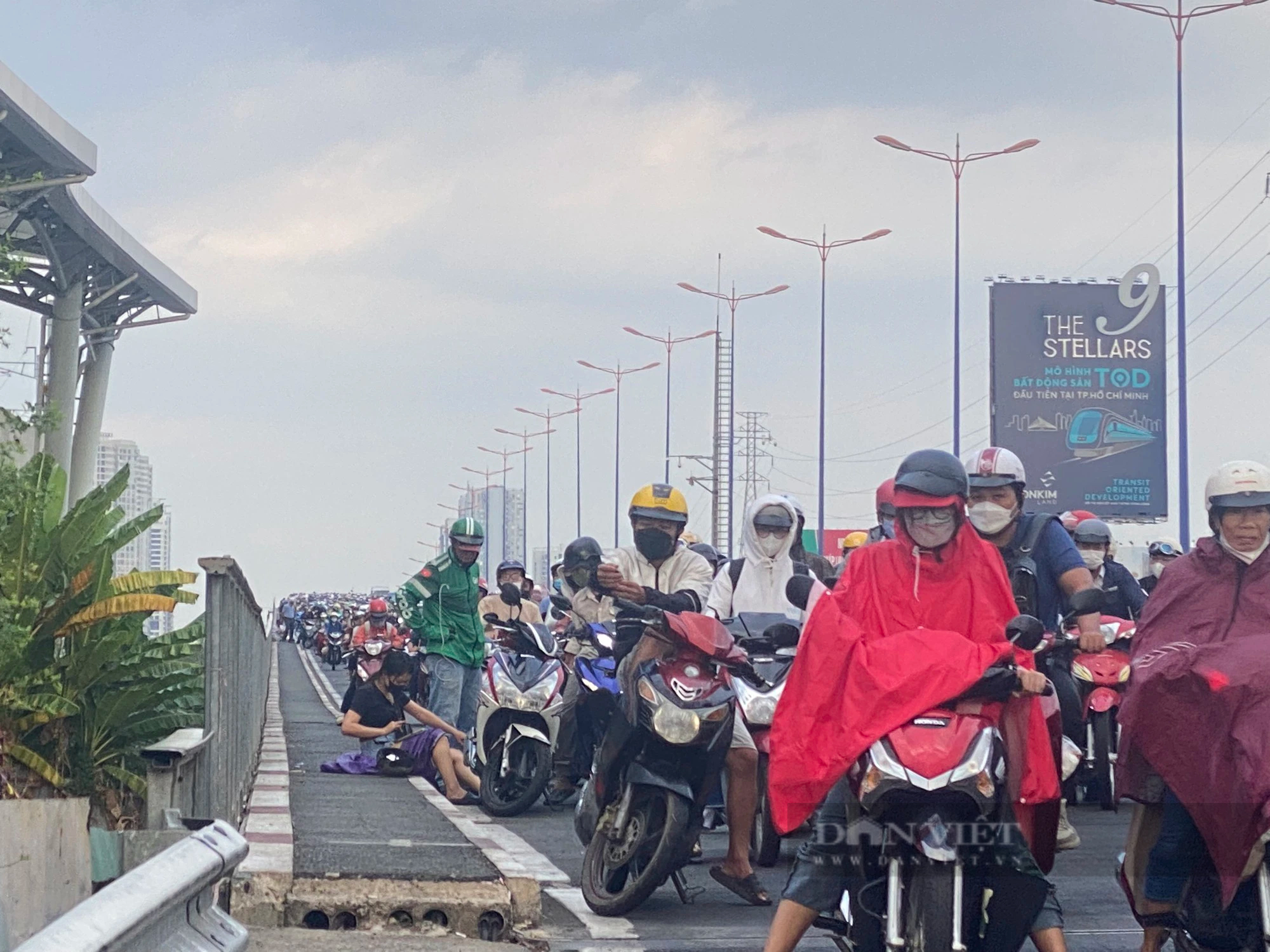 Sau cơn mưa bất ngờ, nhiều người đi xe máy té ngã trên cầu Sài Gòn khiến giao thông ùn ứ- Ảnh 1.
