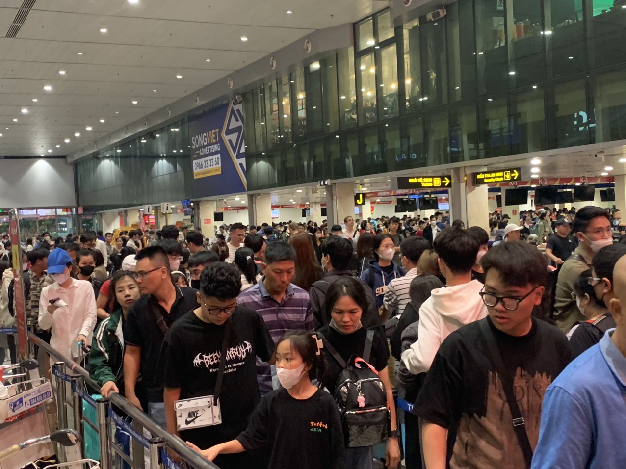 Sân bay Tân Sơn Nhất chật kín người về quê đón Tết, các quầy làm thủ tục quá tải, nhiều chuyến bay bị chậm trễ- Ảnh 1.