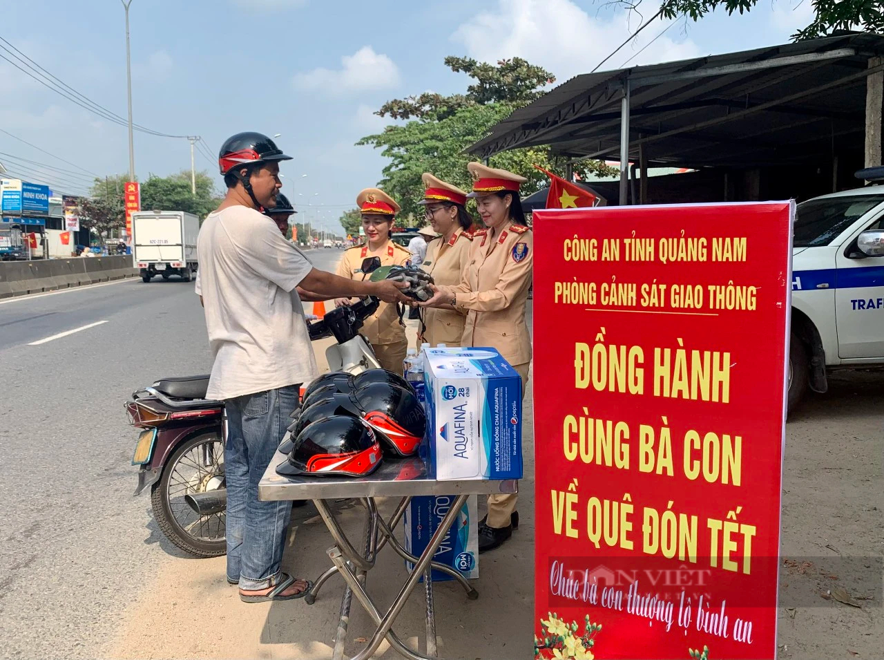 Nữ CSGT Quảng Nam tặng, đội mũ bảo hiểm cho người dân trên đường về quê ăn Tết- Ảnh 1.