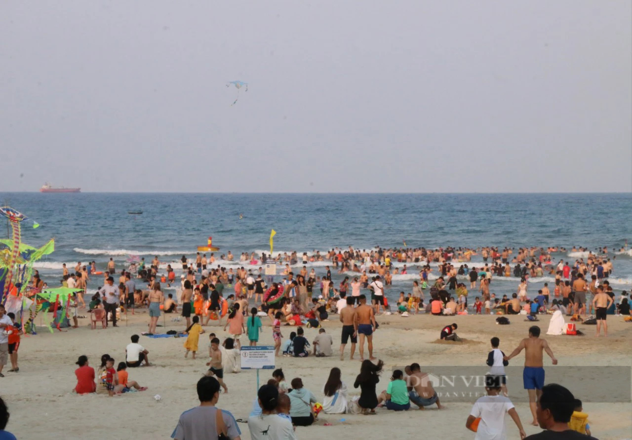 Nắng nóng, người dân và du khách ùn ùn đổ về các bãi biển Đà Nẵng "giải nhiệt"- Ảnh 1.