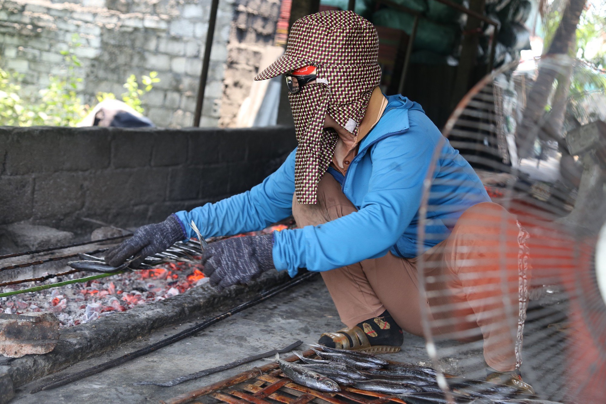 Nắng hơn 40 độ C, hàng chục phụ nữ vẫn ngồi trước lò than hồng nóng 100 độ C nướng từng vỉ cá thơm phức- Ảnh 2.