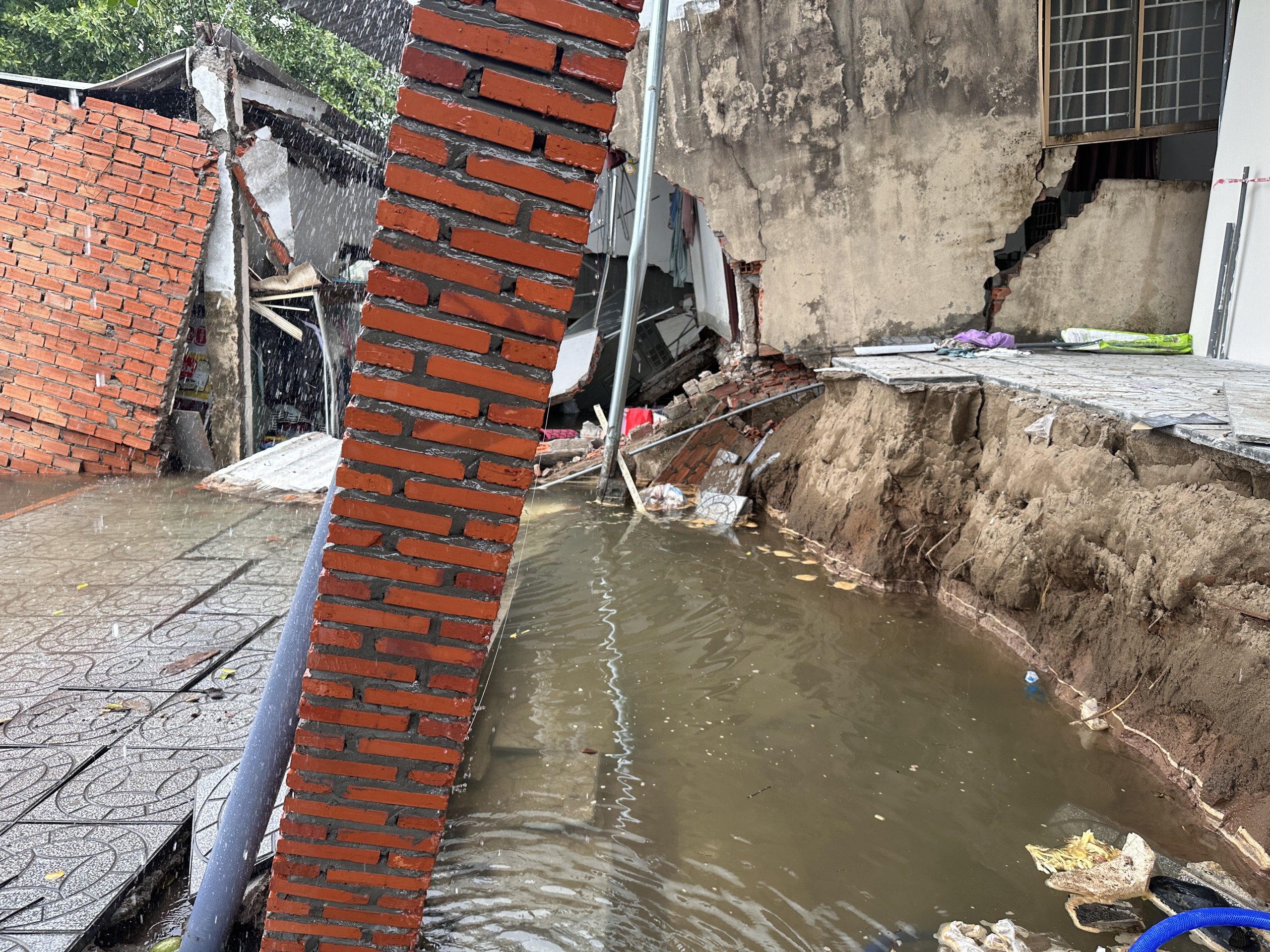 Nóng: Sạt lở ở Cần Thơ, 10 căn nhà chìm dần xuống sông Bình Thủy, người dân dầm mưa khắc phục hậu quả- Ảnh 1.