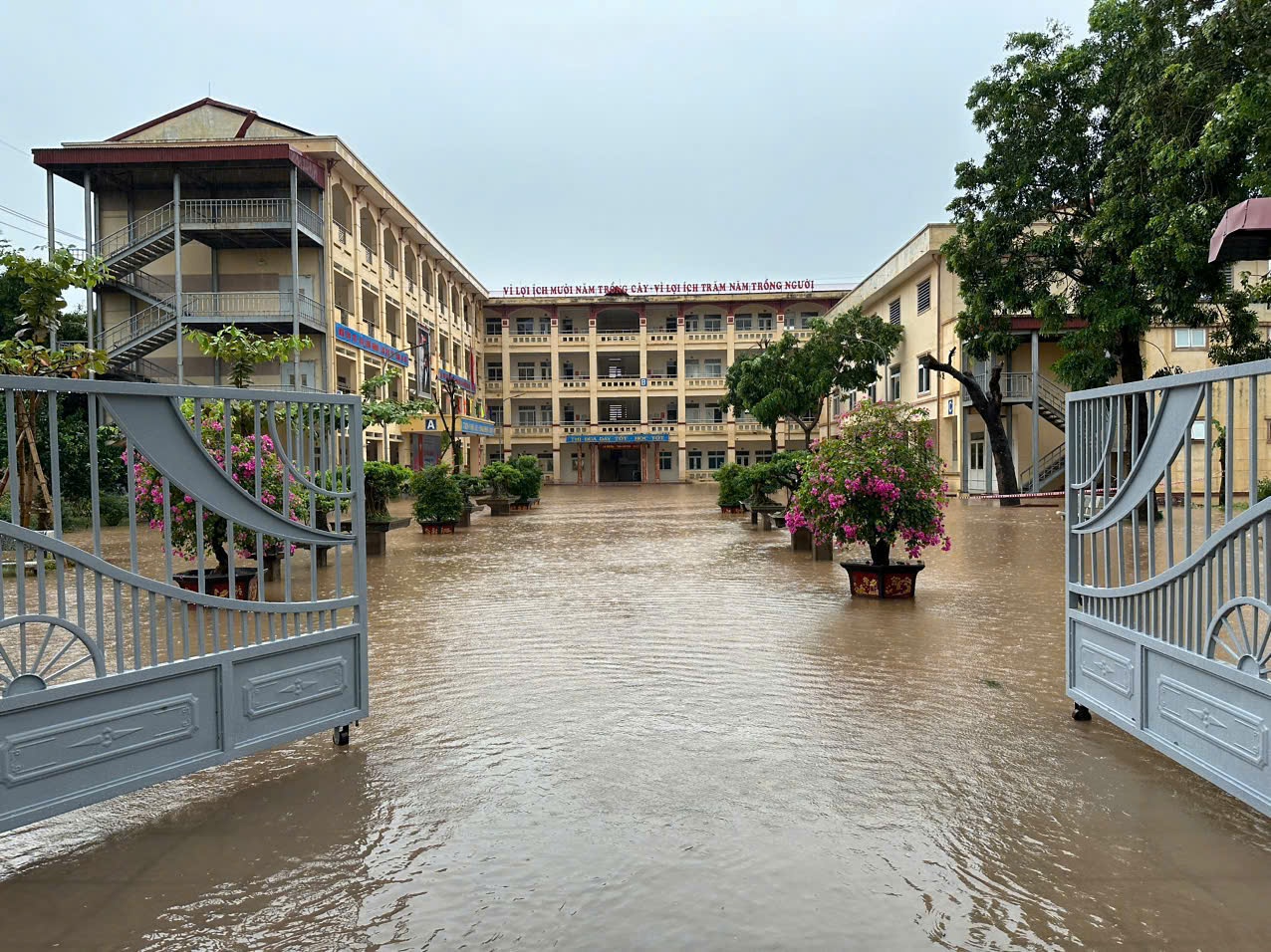 Học sinh Hà Nội bì bõm đến trường vì ngập sâu, có nơi nghỉ học hoặc chuyển sang học online- Ảnh 1.