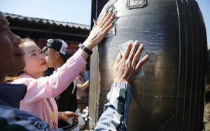 Du khách thi nhau chà tiền "đánh bóng" chùa Đồng trên đỉnh Yên Tử
