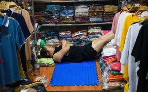 Tiểu thương ngồi bấm điện thoại, nằm dài chờ khách tại chợ thời trang lớn nhất Hà Nội