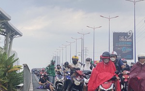 Sau cơn mưa bất ngờ, nhiều người đi xe máy té ngã trên cầu Sài Gòn khiến giao thông ùn ứ