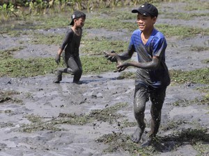 Cho trẻ lội bùn bắt cá dịp đầu năm, lấm lem nhưng vui hơn Tết