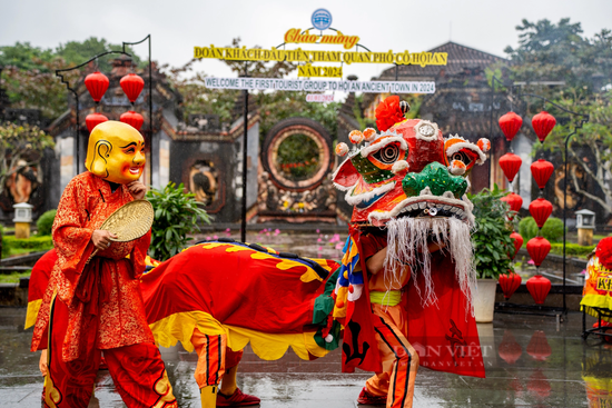 Bất chấp mưa lớn, du khách đội nón lá, thích thú tham quan phố cổ Hội An ngày Tết Dương lịch 2024 - Ảnh 3.