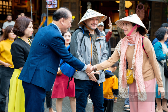 Bất chấp mưa lớn, du khách đội nón lá, thích thú tham quan phố cổ Hội An ngày Tết Dương lịch 2024 - Ảnh 6.