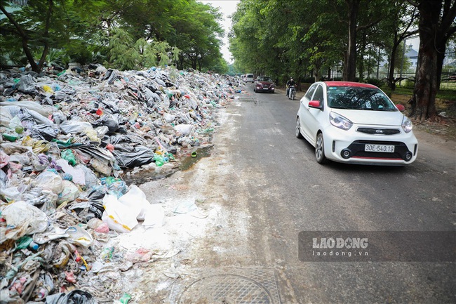 Hà Nội ùn ứ rác: Người dân ngã sõng soài vì một tay lái xe, một tay bịt mũi - Ảnh 3.