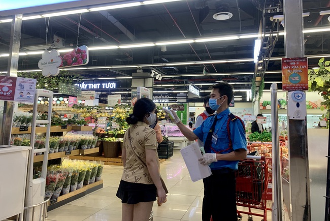 Khách hàng đo thân nhiệt trước khi vào mua sắm tại Lotte Mart Cộng Hoà (Q.Tân Bình). Ảnh: Q.N