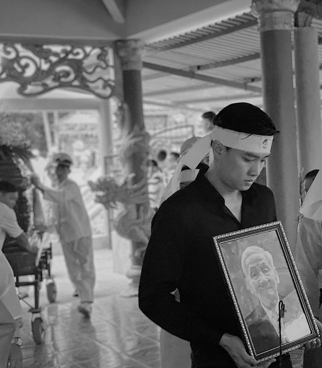 Nghẹn ngào hình ảnh Quốc Trường ôm di ảnh ông nội, đứng thẫn thờ trong đám tang - Ảnh 1.