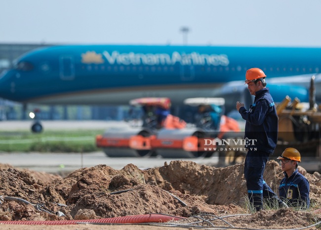 Công nhân đội nắng 60 độ C trên &quot;đại công trường&quot; cải tạo đường băng sân bay Nội Bài - Ảnh 1.