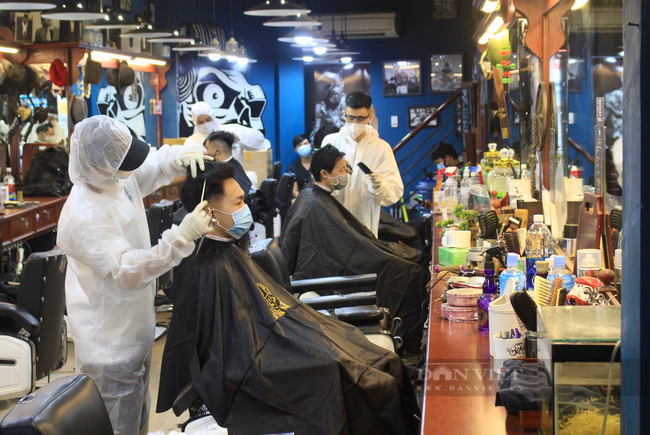 ẢNH: Người Sài Gòn xếp hàng cắt tóc, thợ mặc đồ bảo hộ, đổ mồ hôi hột ngày đầu mở lại - Ảnh 1.