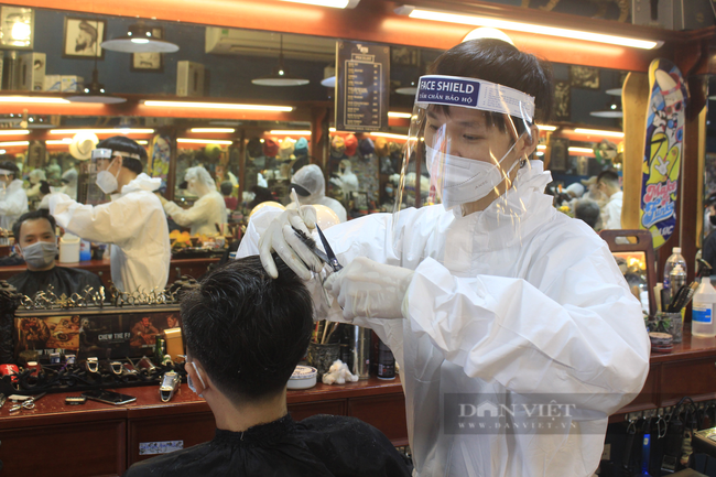 ẢNH: Người Sài Gòn xếp hàng cắt tóc, thợ mặc đồ bảo hộ, đổ mồ hôi hột ngày đầu mở lại - Ảnh 4.
