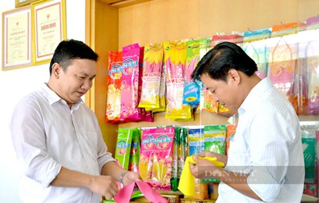 Ông Lê Bạch Long (trái) giới thiệu về sản phẩm găng tay cao su do doanh nghiệp sản xuất. Ảnh: Nam Long