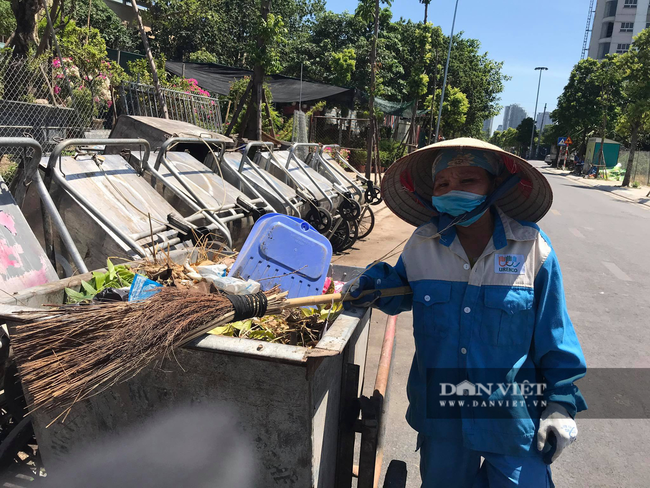 Dù gần 11 giờ trưa, nhưng bà Đệ vẫn chưa được nghỉ vì chưa bốc xong mấy chục xe rác. Ảnh: N.T