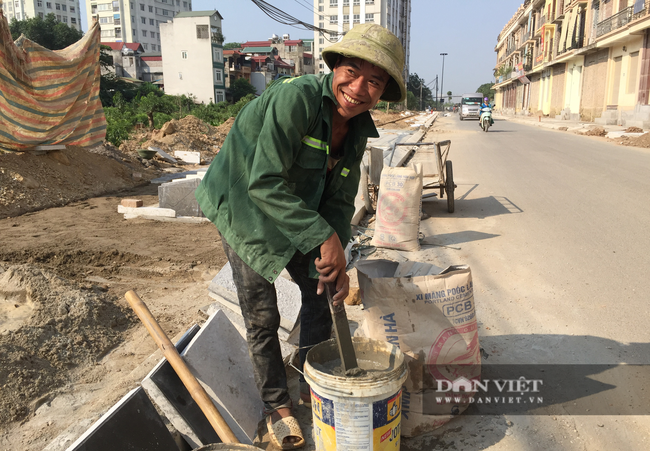 Lao động Lê Văn Nam, một lao động trong nhóm thợ xây được thuê lát gạch vỉa hè tại Đại Mỗ. Anh Nam cho biết: &quot; Dù biết đang có dịch nhưng nắng nóng, mồ hôi nhiều nên đôi lúc tháo khẩu trang thở chút&quot;. Ảnh: N.T