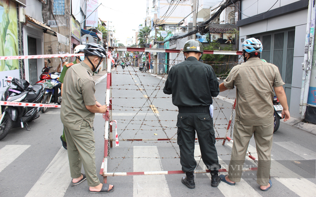 Lực lượng chức năng giăng dây và dựng rào chắn để hạn chế lưu thông trên đường Trần Quang Diệu, quận 3. (Ảnh: Nguyên Vỹ)