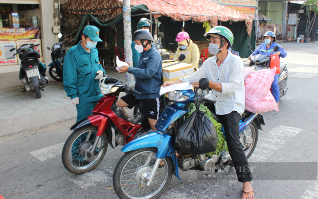 Người dân trình giấy tờ để qua chốt. (Ảnh: Nguyên Vỹ)