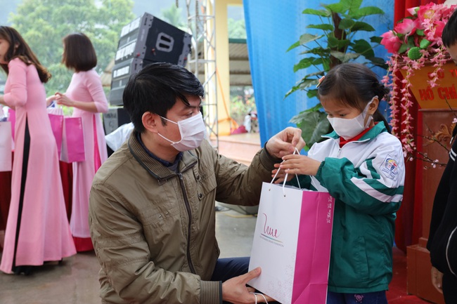 Ông Nguyễn Minh Hoàng - Đại diện Quỹ Vì Tầm Vóc Việt tặng áo và sữa cho các em học sinh. Ảnh: Nguyệt Minh