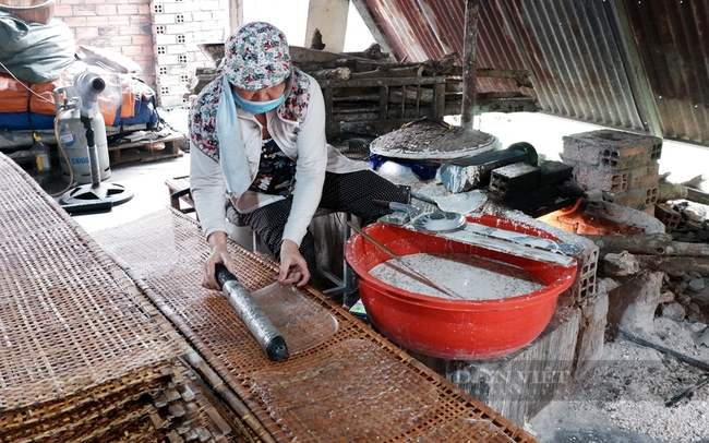 Bánh tráng được người thợ khéo léo trải ra phên trước khi đem đi phơi nắng. Ảnh: Nguyễn Vy